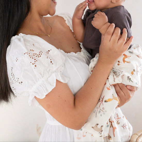 Woman holding a baby against a white background