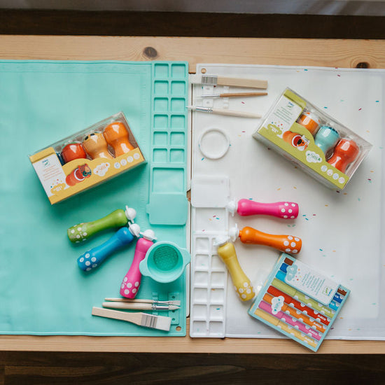 Art supplies including paintbrushes and color swatches on a wooden table.