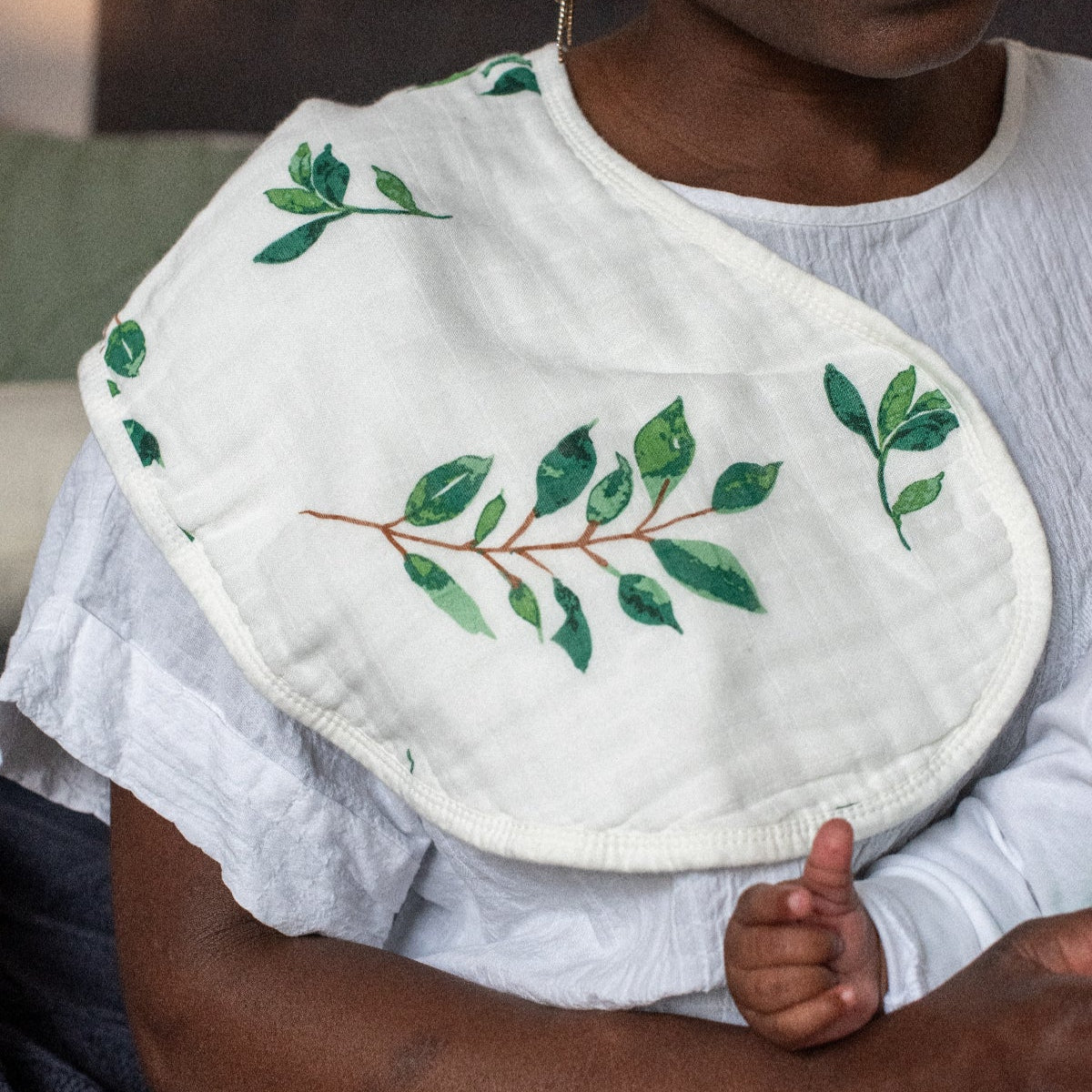 Person wearing a white bib with green leaf patterns