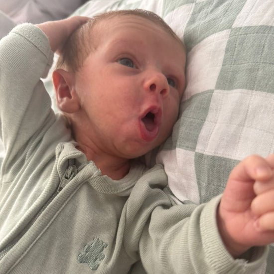 Newborn baby lying on a checkered blanket